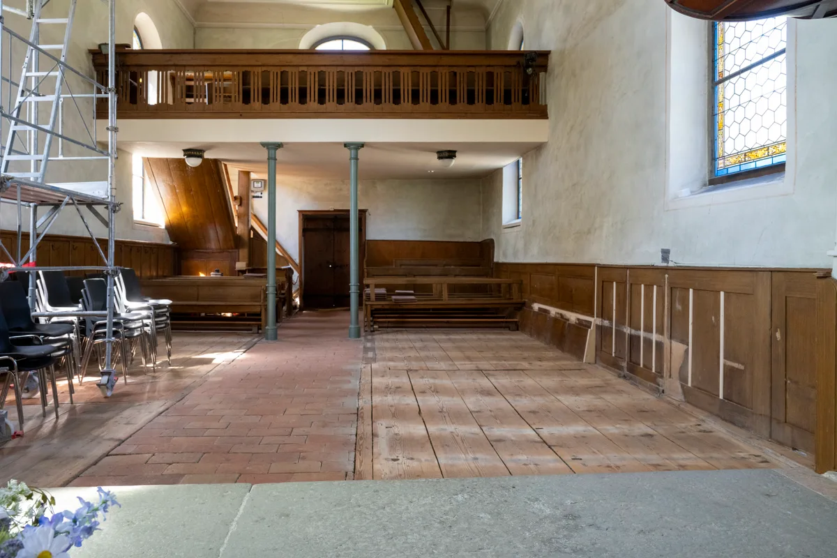 Man sieht eine leere Kirche ohne Bänke.